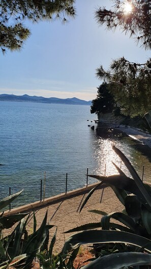A coastal view with a clear sky, calm sea, and distant mountains. - Luxury Majpruz Suites (Zadar)