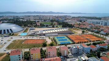 Vista aérea de un paisaje urbano con edificios residenciales, un gran complejo deportivo y un estadio.
