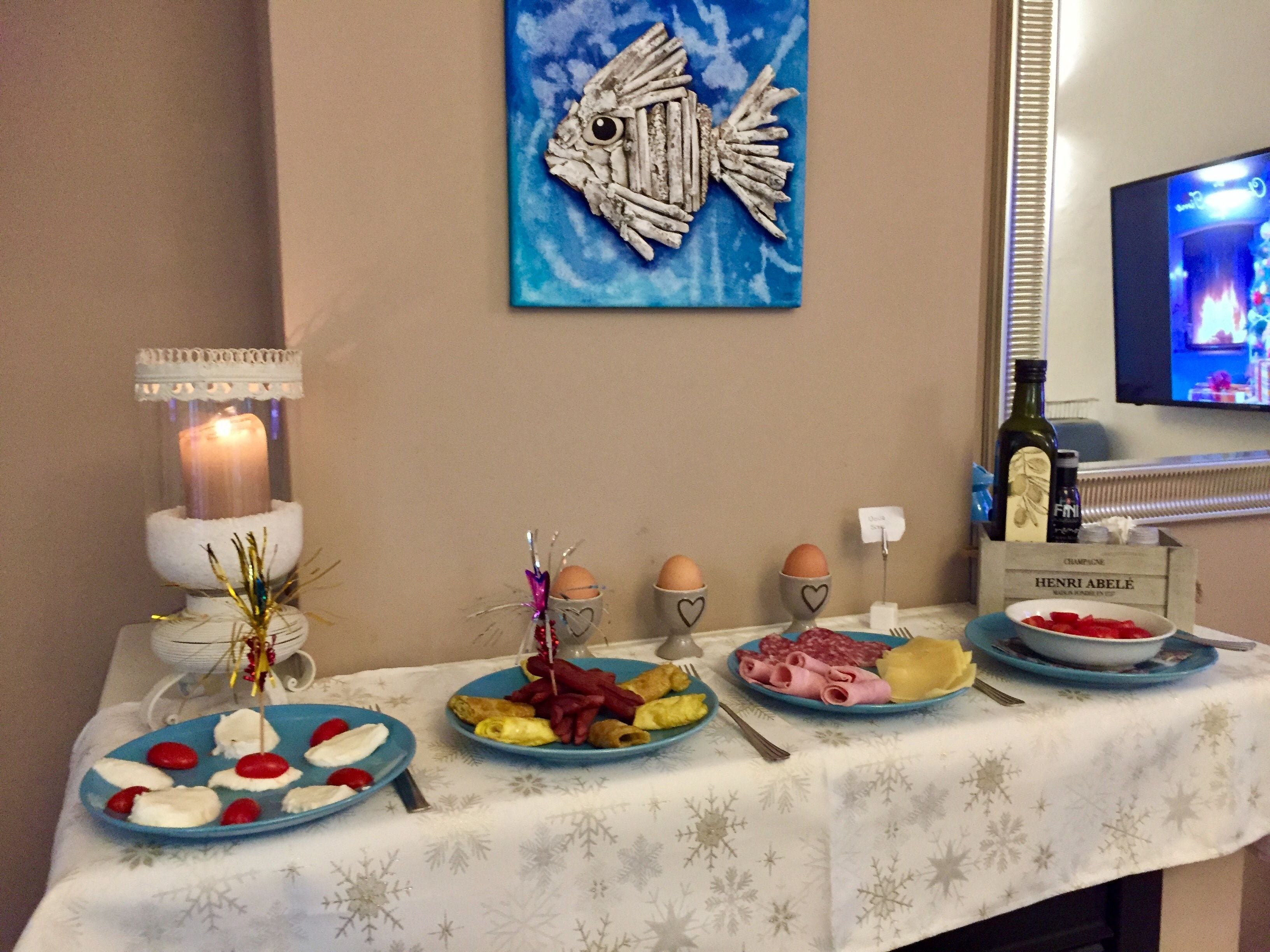 Una mesa de comedor con diversas comidas y una vela.