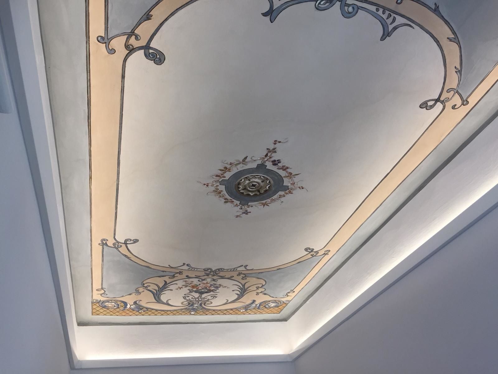 A ceiling with ornate metalwork and floral patterns.