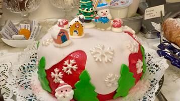 Un gâteau festif décoré de flocons de neige, d’un petit Père Noël et de sapins de Noël.