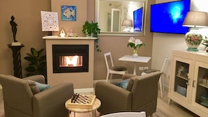 A living room with a fireplace, a television, and a chessboard. - Residenza Elisa (Desenzano del Garda)