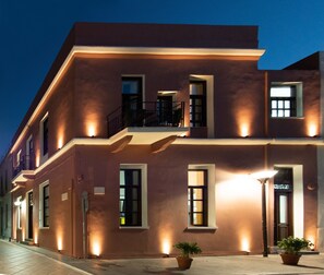 A multi-story building with a flat roof, large windows, and a balcony. - Intra Muros Hostel (Heraklion)