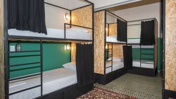 A room with bunk beds, a green wall, and a patterned floor.