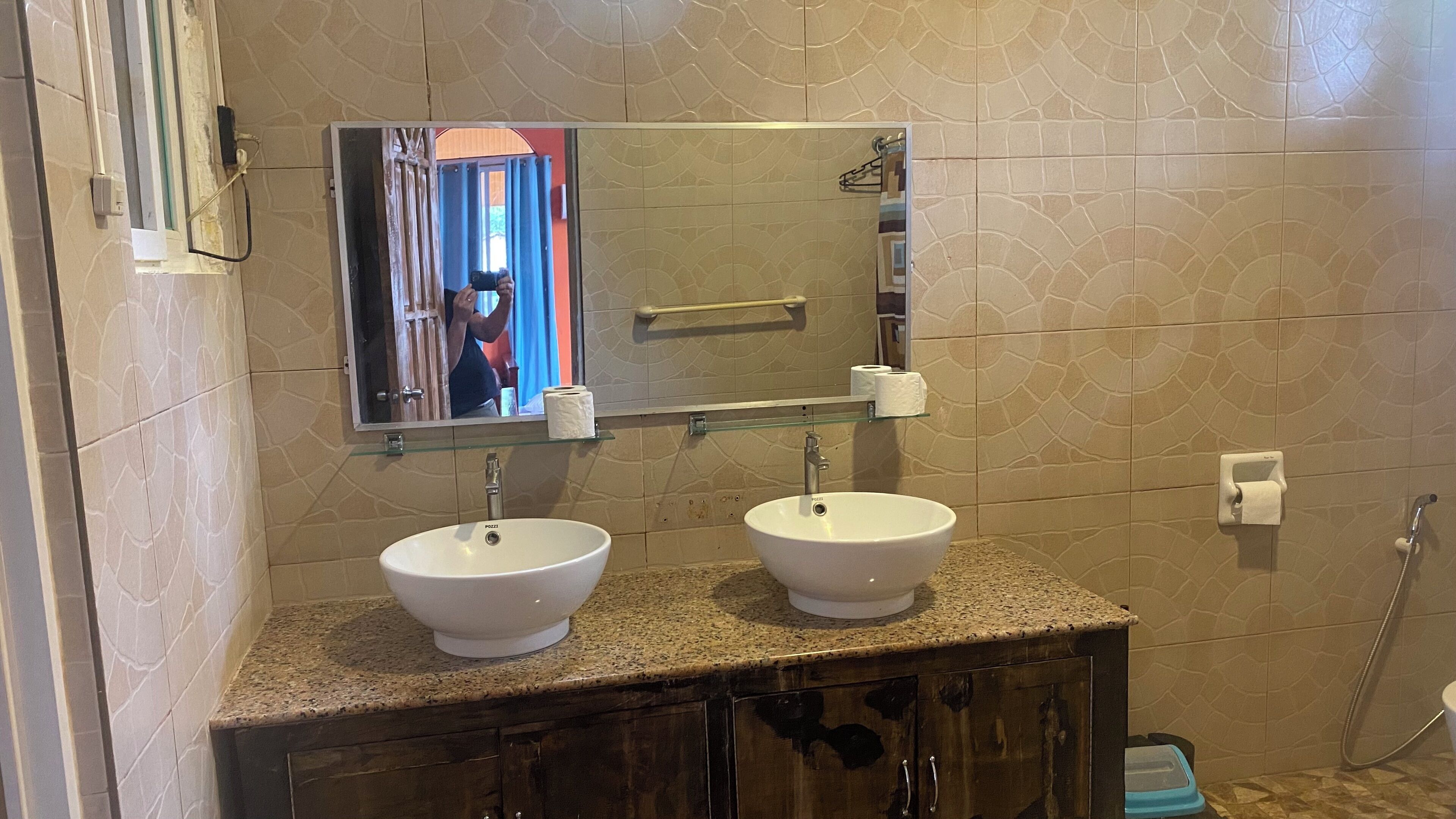 A bathroom with two sinks, a mirror, and a shower.
