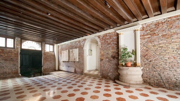 An interior with a patterned floor, brick walls, and wooden beams. - Ca Vecchio Pozzo:Charming property in central historical Venice (VENICE)