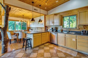 Une cuisine spacieuse avec des meubles en bois, un îlot central et une grande fenêtre.