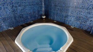 A hot tub with a blue mosaic wall and wooden flooring. - Fidalsa Guardamar Resort (Guardamar)