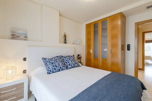 A bedroom with a bed, bedside table, and a wardrobe.