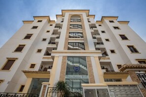 A multi-story hotel with a central entrance, balconies on each floor, and a visible logo on the facade. - Fidalsa Guardamar Resort (Guardamar)