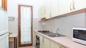 Una cocina equipada con estufa, fregadero, microondas y armarios.