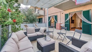 An outdoor patio with wicker furniture, a dining table, and a bar area.