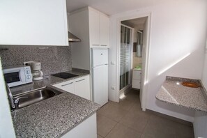 Fridge, microwave, coffee/tea maker, cookware/dishes/utensils