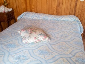 A bed with a floral-patterned bedspread and a single decorative pillow. - Homerez - House in Orsanco (Orsanco)