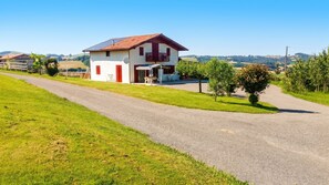 A two-story house with a red roof, a balcony, and solar panels on the roof. - Homerez - House in Orsanco (Orsanco)