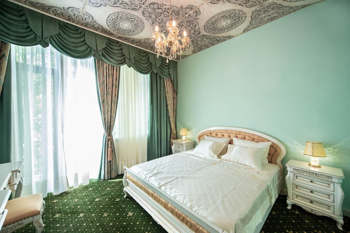 Une chambre à coucher avec un grand lit, un lustre et une table de chevet avec une lampe.