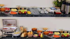 Una mesa de buffet con diversos alimentos y bebidas.