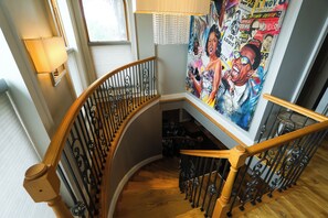 A curved staircase with wooden handrails and metal balusters, leading to a lower level.