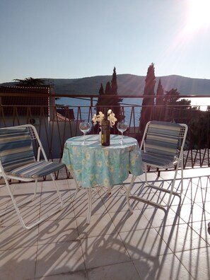 A terrace with a table, two chairs, a bottle, and two wine glasses. - Semi detached house in nature for family vacations (Seget Vranjica)