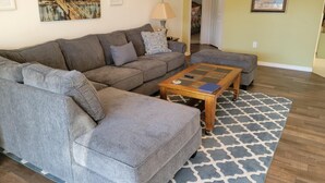 A living room with a sectional sofa, a coffee table, and a patterned rug. - Stay in Luxury, Private Pool/Spa, Games Room, Close to Disney and Golf (Haines City)