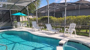 A swimming pool with lounge chairs and a covered area. - Stay in Luxury, Private Pool/Spa, Games Room, Close to Disney and Golf (Haines City)
