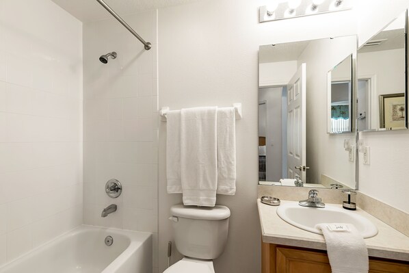A bathroom with a bathtub, toilet, and sink.
