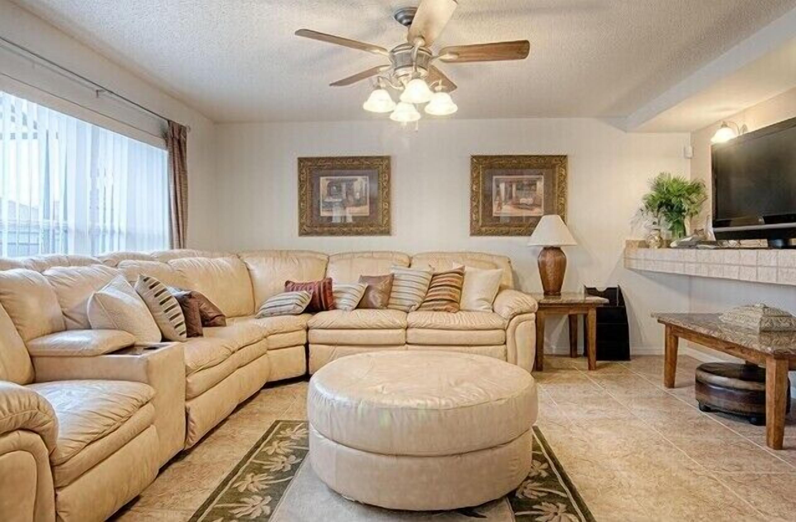 Family room with comfy couch and 60' HDTV, marble end tables,Ottoman & rug