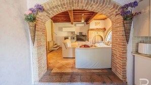 A cozy living area with a brick archway, a fireplace, and a sofa. - Esclusivo per te (COLLE VAL D' ELSA)