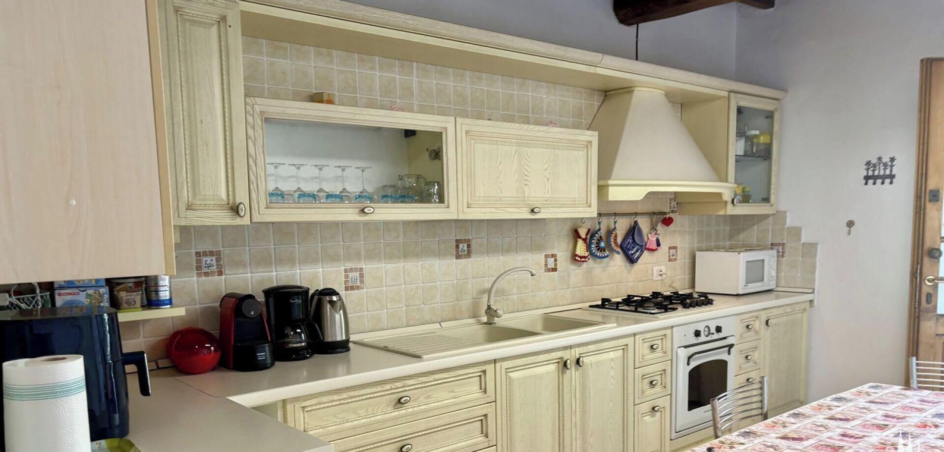 A kitchen with a sink, stove, and cabinets.