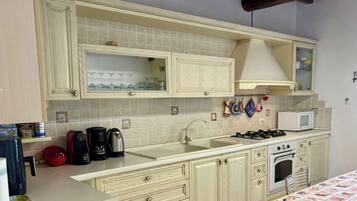 A kitchen with a sink, stove, and cabinets.