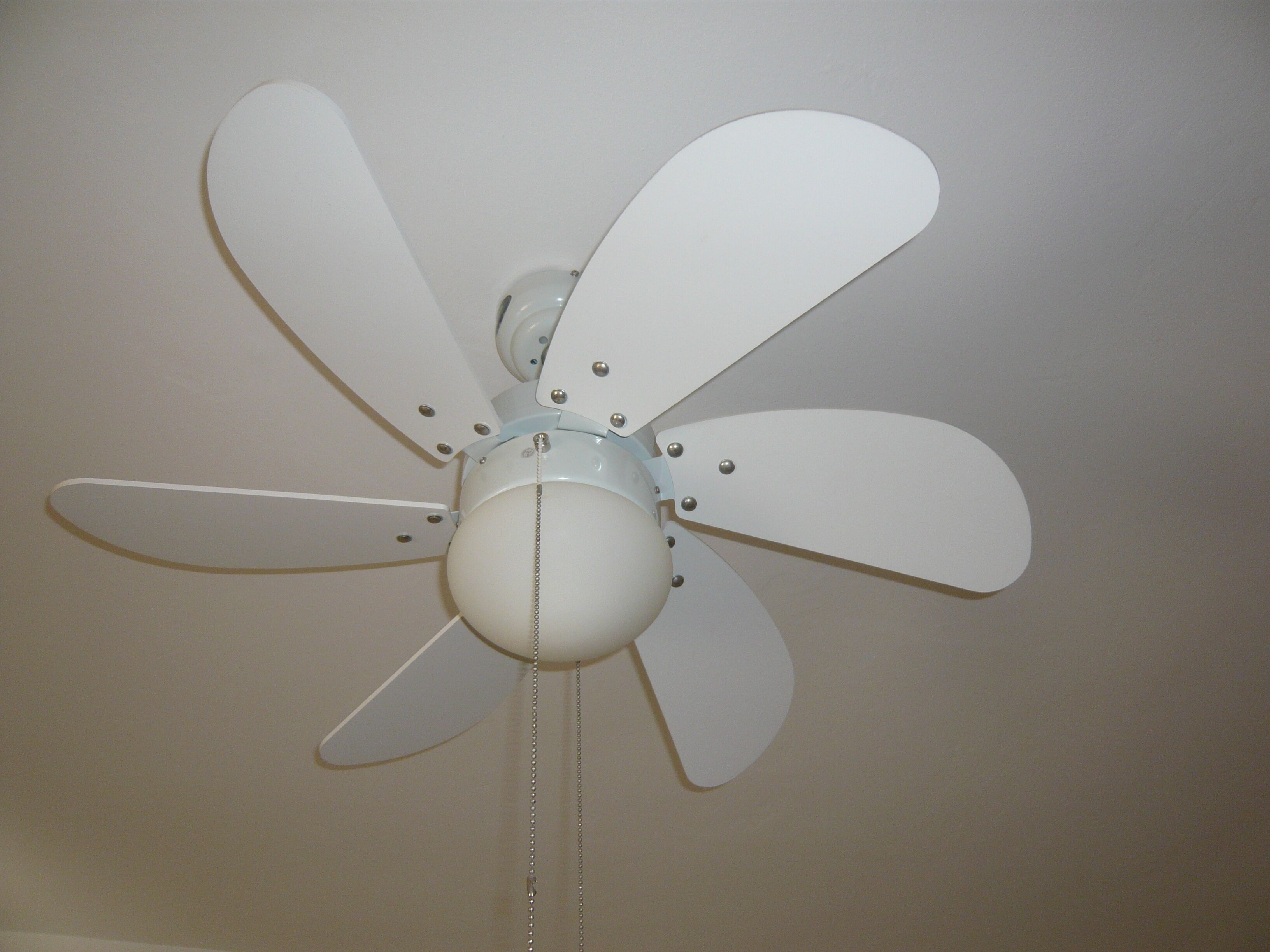 A ceiling fan with five blades and a central light fixture.