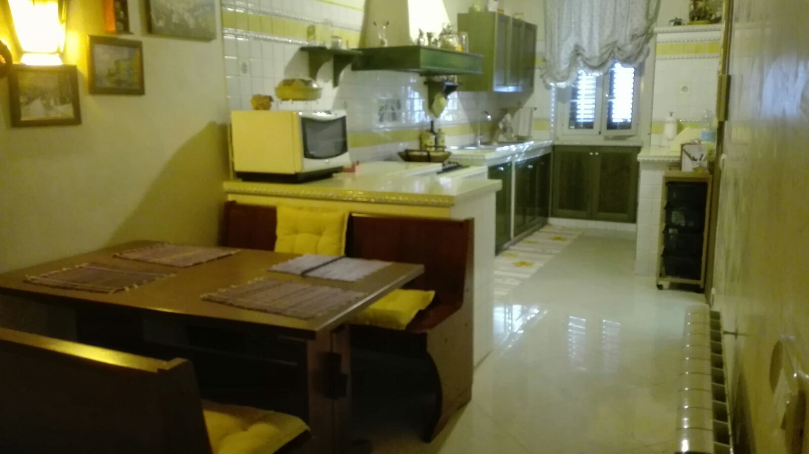 Cocina compacta con comedor, que incluye una mesa pequeña, sillas y electrodomésticos básicos.