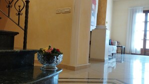 Una escalera de mármol con un cuenco decorativo en un rellano.