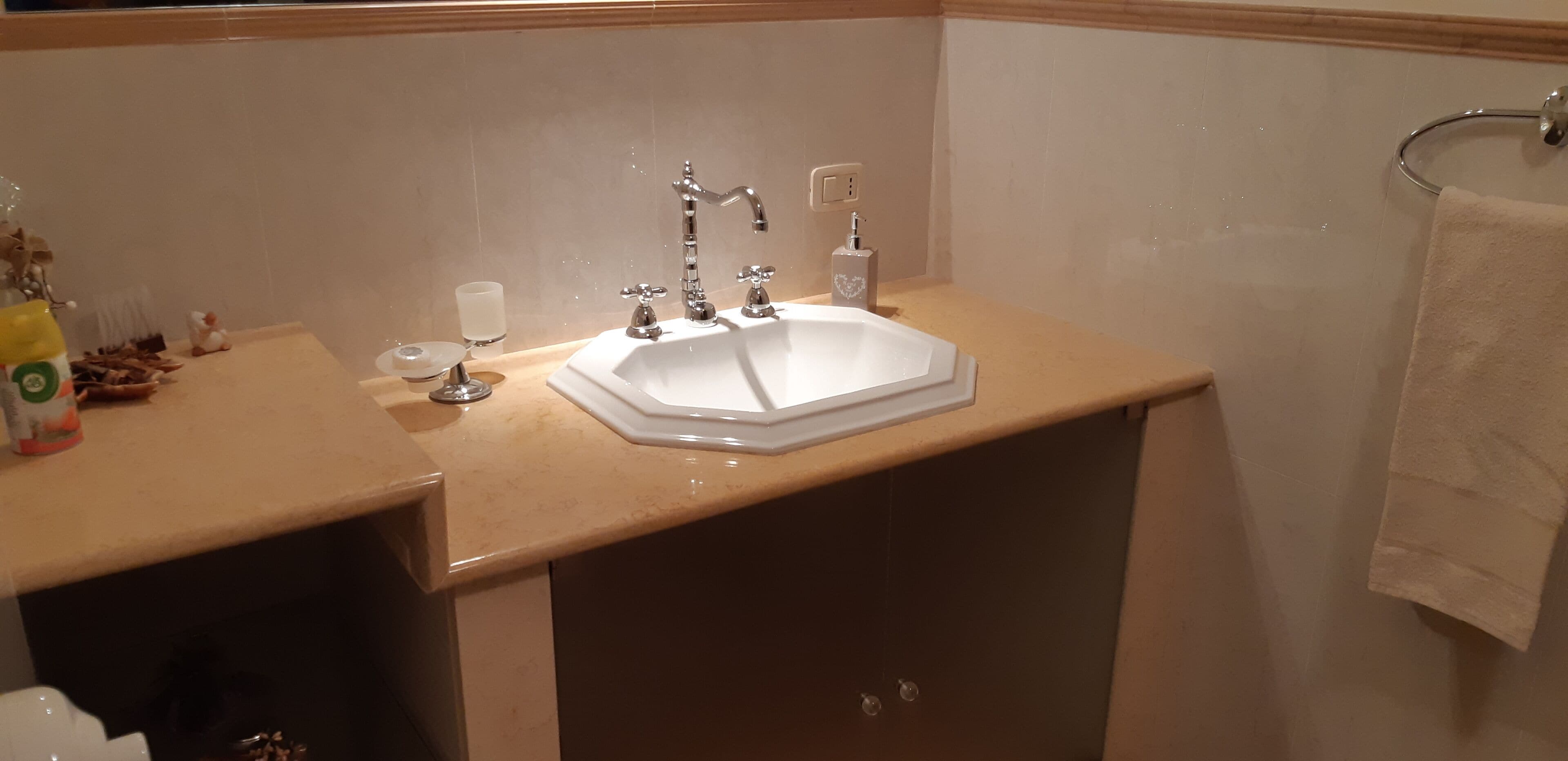 Une salle de bain avec un lavabo blanc, un miroir et un porte-serviettes.