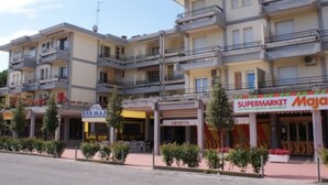 A multi-story building with a ground-floor supermarket and a restaurant. - Peaceful flat in Bibione (Bibione)
