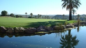 A serene landscape with a pond, green grass, and palm trees. - First Floor Apartment On Golf Resort, Shared PoolWell Equipped Apartment (VERA)