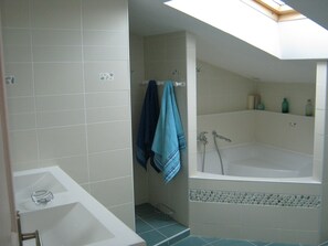 Une salle de bain avec une baignoire, une douche et un lavabo.