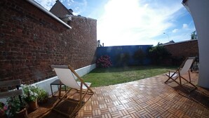 Eine Terrasse mit Holzboden und zwei Holzstühlen.