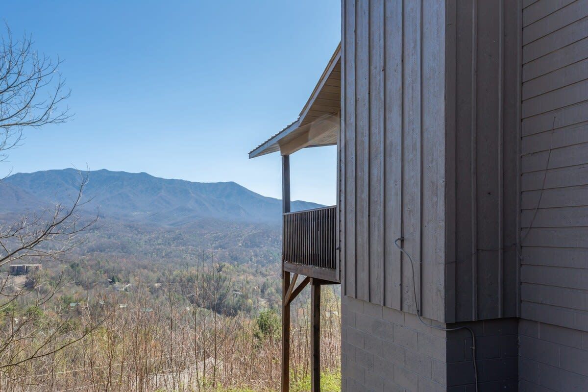 Un bâtiment doté d’un balcon donnant sur un paysage montagneux.