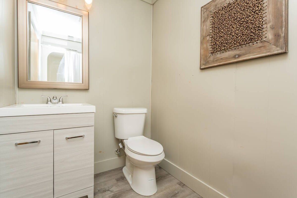 A bathroom with a white sink, a toilet, and a mirror.