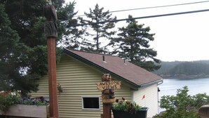 Une cabane en bois avec une pancarte indiquant « Vue imprenable » et donnant sur un lac.