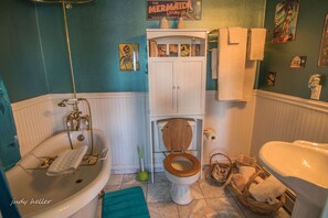 Een bad/douchecombinatie, een haardroger, handdoeken