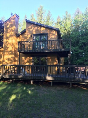 A two-story wooden building with a balcony and a covered walkway. - Multi- family home, 3 levels of living space, King size beds. (Manistee)