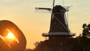 A windmill with a chain in the foreground and a sunset in the background. - Cozy updated 3 BR home steps away from downtown, space to relax and enjoy.  (Holland)