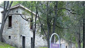 A stone building with a sign indicating 'Horarios' and 'Visitas'. - Departamento Temporario (Villa Carlos Paz)