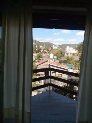 Un balcon offrant une vue sur le paysage urbain, avec des bâtiments et une colline.