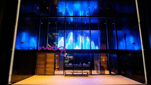 A modern building with a glass facade and a neon sign. - Moxy NYC Downtown (New York)