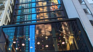 A modern building with reflective glass windows and a visible logo. - Moxy NYC Downtown (New York)