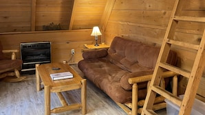 Een gezellig houten interieur met een bank, een tafel en een open haard.