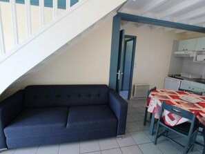 Cozy living space with a sofa, dining area, and compact kitchen.